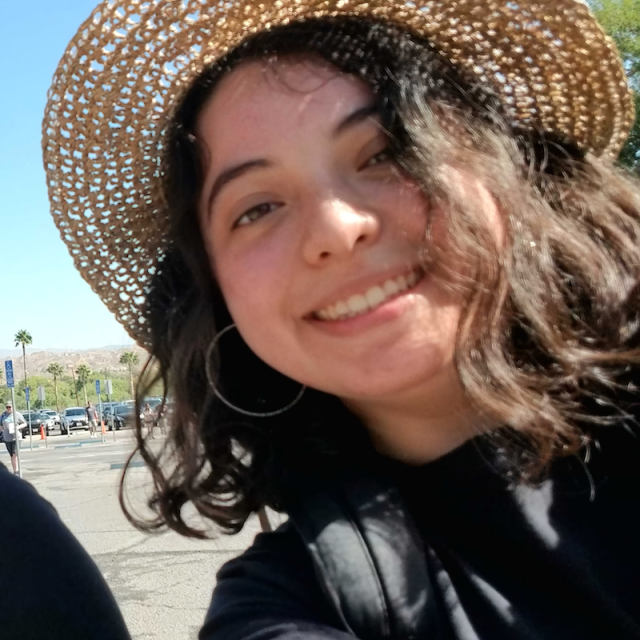 Headshot of James Lopez. She is wearing a brimmed sun hat and a black long sleeved shirt.